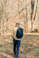 Young handsome man with autumn tree in background. Handsome man in the park. Autumn scenery