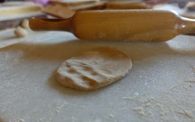 Fototapeta na wymiar Fresh Indian roti dough next to rolling pin