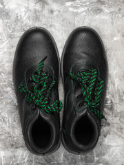 Leather work boots on gray concrete background. Top view