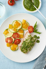 Keto dinner with white fish. Oven baked fillet of cod, pike perch with vegetables and pesto sauce