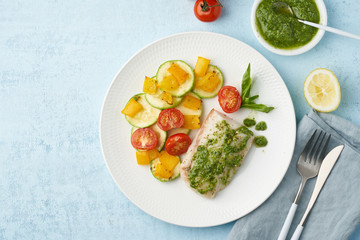 Keto dinner with white fish. Oven baked fillet of cod, pike perch with vegetables and pesto sauce