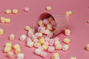 Mini bucket with a lot of marshmallows on a pink pastel background. Minimalism. Sweets
