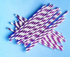 Top view of colorful paper disposable eco-friendly straws. Drinking straws with purple strips for...