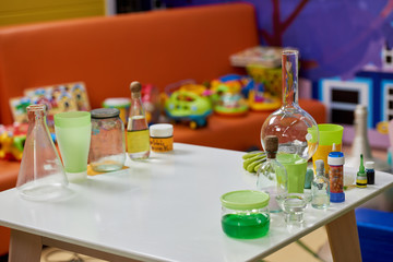 Laboratory glassware on table in playroom. Chemistry lessons for kids. Birthday party gift ideas.