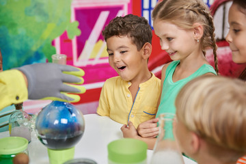 Science show for kids. Animator holding laboratory glassware with colored liquid. Steaming liquid...