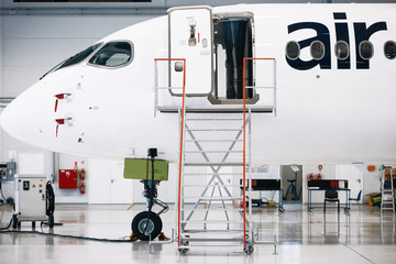 Fototapeta premium Airplane in a white hangar for maintenance