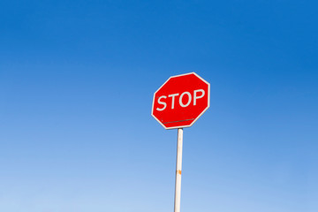 Stop sign against the blue sky. Danger warning.