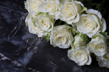 Bouquet of white roses on a background of black marble