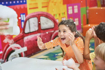 Joyful kids watching dry ice boo bubbles experiment. Happy children at Birthday party science show....
