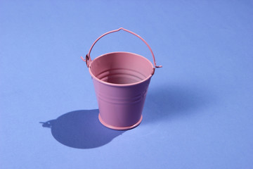 Empty mini pink bucket on purple background. Studio shot with shadow © splitov27