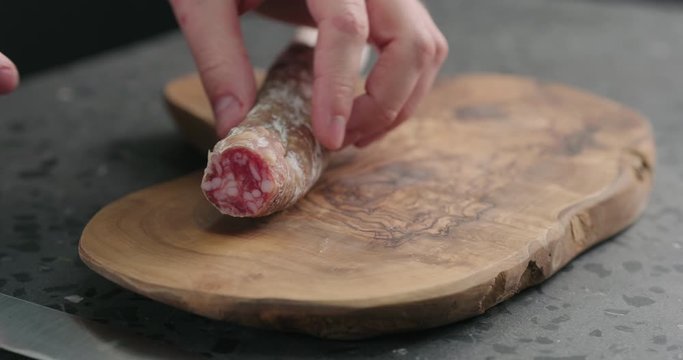 Slow motion mah hands peeling fuet sausage