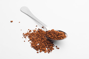 Metal spoon with granulated coffee on a white background