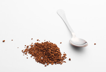 Metal spoon with granulated coffee on a white background