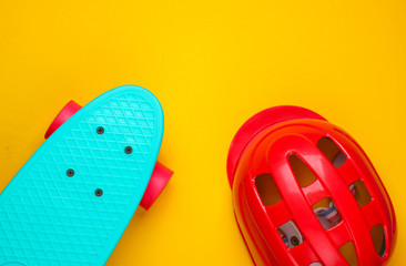 Cruiser board and safety helmet on a yellow background. Protective equipment for sports. Childhood. Top view