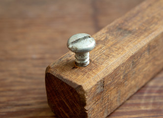 Wood crafted handmade bottlecap opener for beer bottles built with a piece of wood and a metal screw