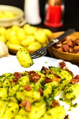 Homemade gnocchi with spinach and Prosciutto on black slate board.  Traditional italian food. Potato gnocchi. Gnocchi with spinach and garlic.