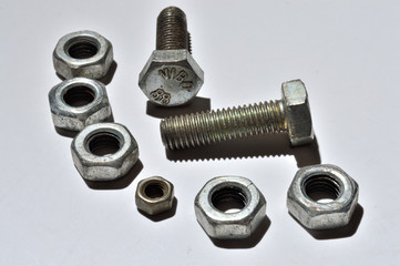 bolts and nuts of different sizes lie on a white background. top view.
