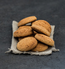 Shortbread oatmeal cookies with milk on a dark gray background