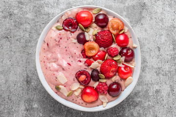 smoothie bowl or nice cream made of frozen bananas and berries with fresh berries, nuts and seeds. healthy breakfast