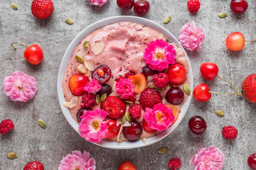 healthy breakfast dessert. smoothie bowl or nice cream with fresh berries, nuts, chia seeds and rose flowers