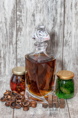 A curved crystal decanter with homemade moonshine stands on a wooden stand
