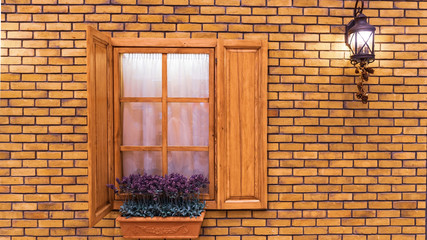 Fototapeta na wymiar Street lamp on the yellow brick wall and pot with lavender on the windowsill.