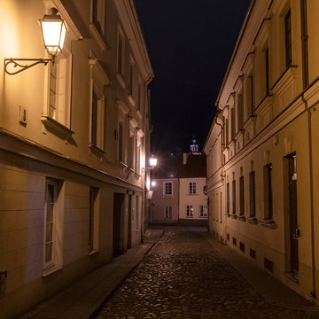 Old street at night. Vintage street llamp on the wall building.