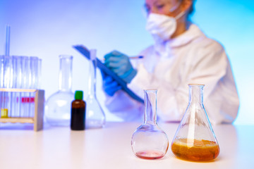 Girl Chemist. Chemical laboratory. Work as a laboratory assistant. A woman writes down test results. Laboratory research. The student conducts chemical experiments. Working with chemicals