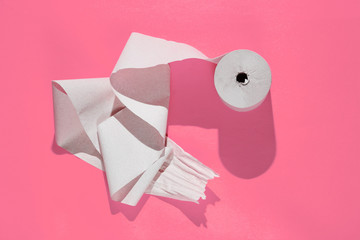 Roll of toilet paper on a pink background.