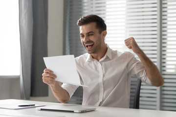 Overjoyed male employee feel euphoric reading pleasant letter