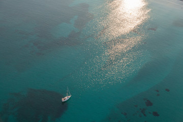 Boat at sunset on emerald waters aerial photography