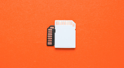 Two Mini SD memory cards on orange background. Top view
