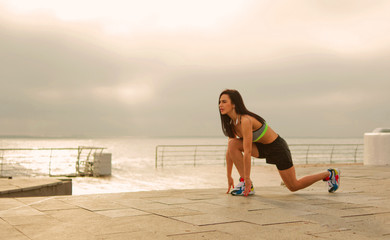 Young sport woman in sportswear getting ready run on beach