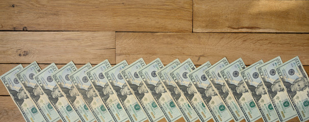 Banner sized background of used dollars 20 dollar banknotes lying on wooden table. Obverse (face) side up.