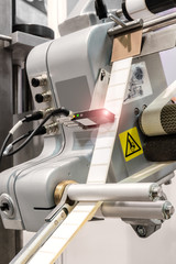 Fragment of the conveyor of sticking labeling machine. Abstract industrial background.