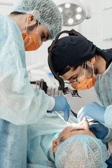 Dentists will perform an operation, implant placement. Real operation. Tooth extraction, implants. Professional uniform and equipment of a dentist. Healthcare Equipping a doctor&rsquo;s workplace. Dentistry