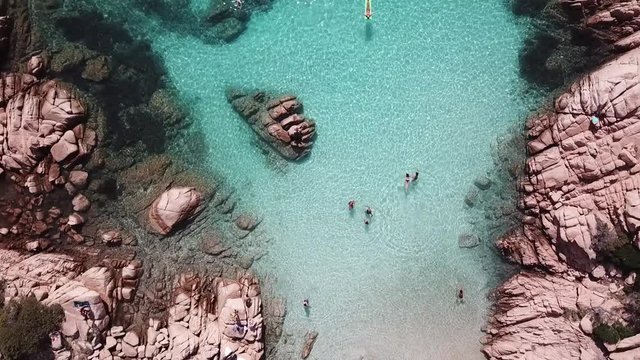 Drone video of beautiful Cala Coticcio, Sardinia, Italy. People swimming in crystal clear turquoise water. 