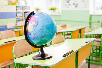 Earth globe on the yellow desk at classroom