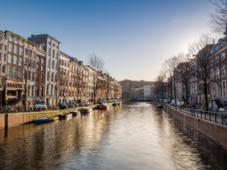 Naklejka premium Amsterdam City Canal view with cloudy sky background