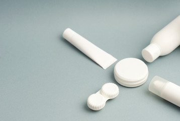 Collection of various beauty hygiene containers on soft gray background. Space to fill