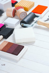 handicraft equipments, ink pads, lino cutter, paint roller and plasticine blocks on white wood table