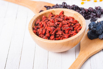 dried goji, cherry, raisin and plum fruits on white wood