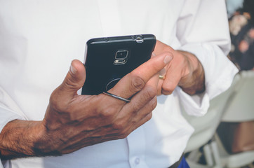 A man stands and holds a phone in his hands. Exchange messages.