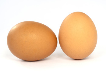 Two brown chiken eggs on white background