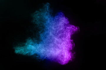 Freeze motion of blue and pink color powder exploding on black background.