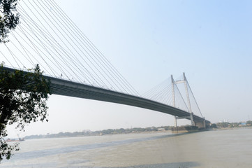 Obraz premium Panoramic Vidyasagar Setu or Hooghly Bridge during sunset. Famous longest cable stayed toll flyover over Ganges River connection cities Kolkata and Howrah. Calcutta West Bengal India South Asia Pac.