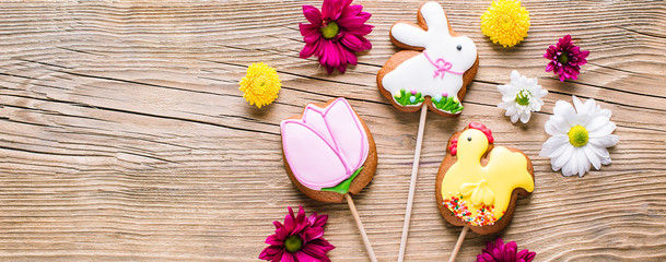 Easter cookies, gingerbread in the shape of a rabbit and chicken, spring Easter background with flowers, long banner