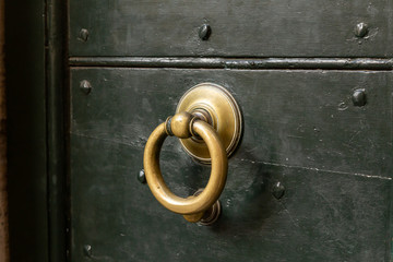 green wooden door of building, detail of door knocker
