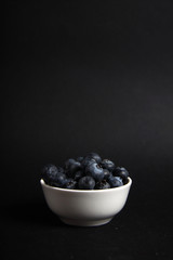 a bowl of blueberry isolated on black background