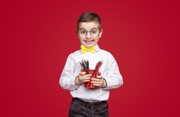 Funny schoolboy with colored pencils